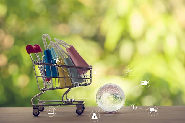 Online-Shopping, E-Commerce-Konzept: Papiertüten in einem Wagen oder Einkaufswagen mit Symbol Kundennetzwerkverbindung. Beim Kauf von Produkten im Internet können Waren aus dem Ausland gekauft werden