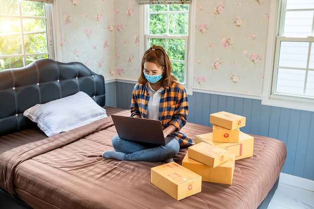 Online-Shopping junge Frauen starten kleine Unternehmen in einem Karton bei der Arbeit.