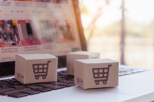 Online-Shopping Karton mit Warenkorb-Logo auf der Laptop-Tastatur Einkaufsservice im Online-Web bietet Lieferung nach Hause