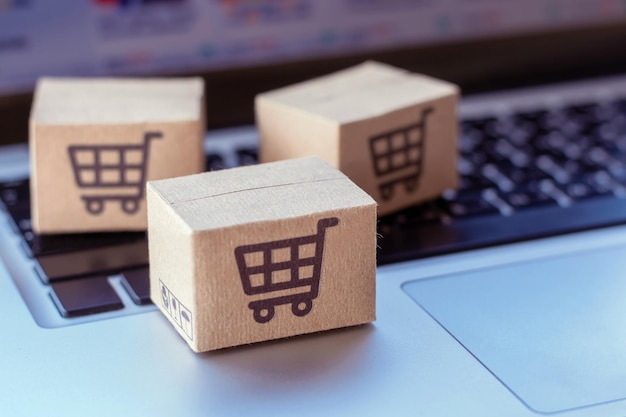 Online-Shopping Karton mit Warenkorb-Logo auf der Laptop-Tastatur Einkaufsservice im Online-Web bietet Lieferung nach Hause