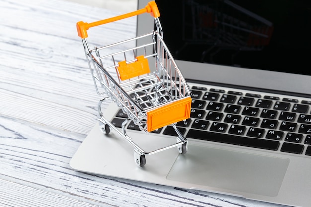 Online-Shopping Mini Warenkorb und Laptop