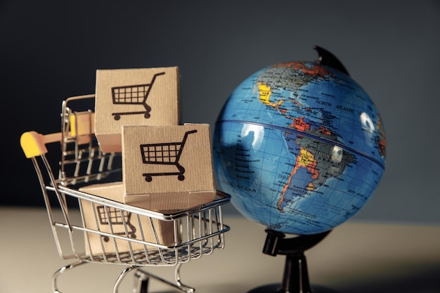 Online-Shopping und E-Commerce-Konzept Globus und Supermarkt-Einkaufswagen mit Boxen