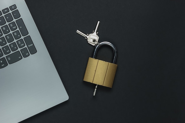 Online-Sicherheit. Internet Schutz. Passwort für den Computer. Laptop und Vorhängeschloss mit Schlüssel auf schwarzem Hintergrund.