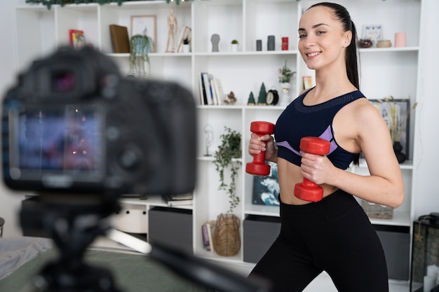 Online-Sport-Fitness-Trainerin, die ihre Sitzung aufzeichnet