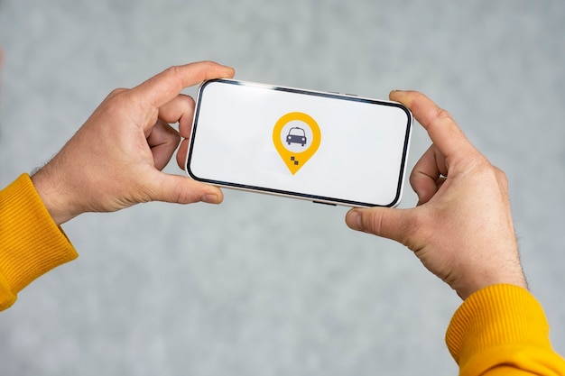 Online-Taxi auf Ihrem Handy. Ein Mann hält ein Smartphone mit einem weißen Bildschirm und einem Geolocation- und Standortsymbol für ein Taxi.