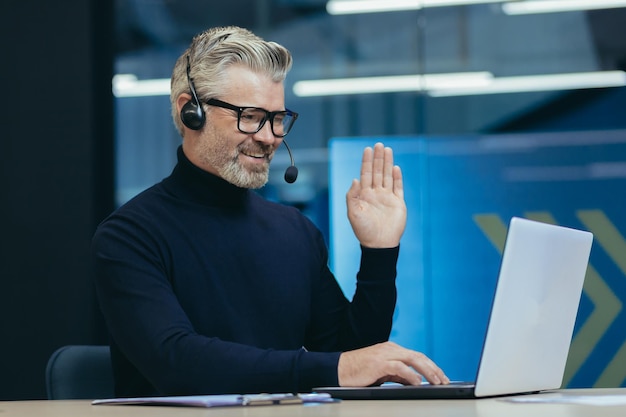 Online-Treffen mit Kollegen, einem älteren, grauhaarigen Mann, der in einem modernen Büro-Interieur-Executive arbeitet