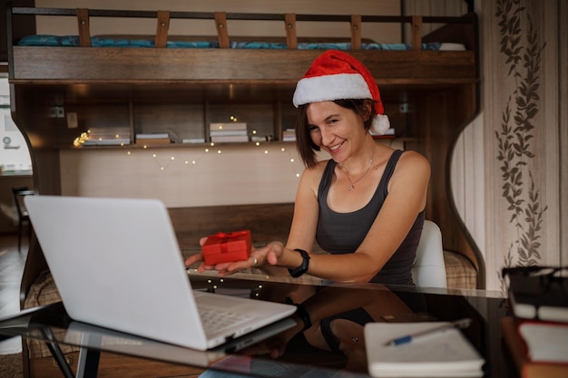 Online-Weihnachtsglückwünsche Lächelnde Frau, die einen PC für Videoanrufe an Freunde oder Eltern verwendet