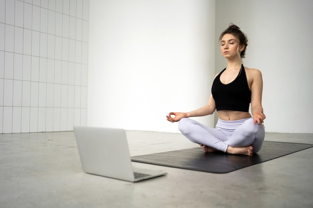 Online-Workout Frau Yoga Sport und flexibler Körper macht Asana-Pose in einem Fitnessclub