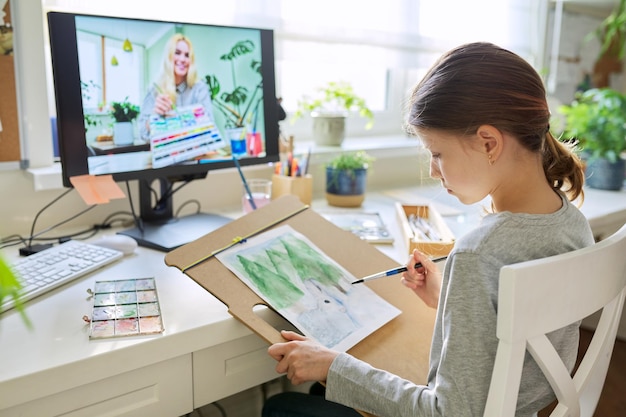 Online-Workshop zum Zeichnen Mädchen-Kind-Student, der zu Hause mit Wasserfarben malt