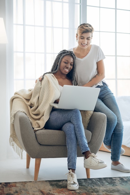 Online. Zwei Mädchen schauen sich etwas auf einem Laptop an und sehen involviert aus