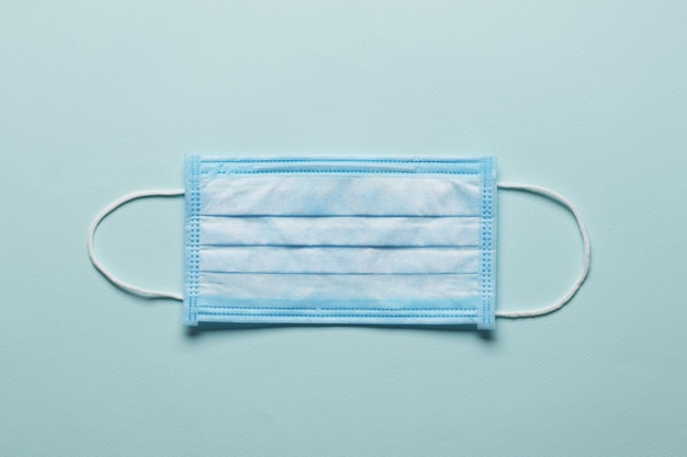 OP-Maske mit Gummi-Ohrbügeln. Typische 3-lagige OP-Maske zum Abdecken von Mund und Nase. Prozedurmaske aus Bakterien. Schutzkonzept.