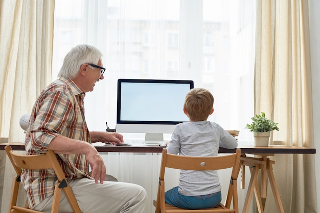 Opa hilft Jungen bei den Hausaufgaben