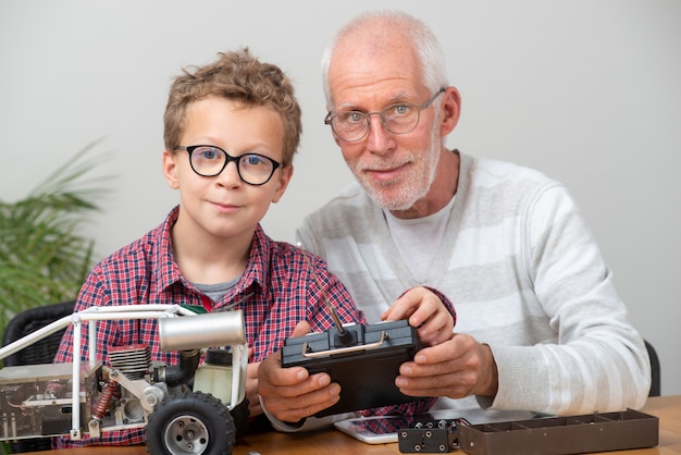 Opa und Sohn kleiner Junge reparieren funkgesteuertes Modellauto