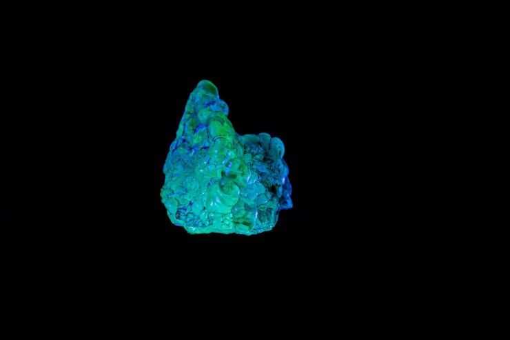Foto opala de pedra mineral macro sob luz ultravioleta em um fundo preto