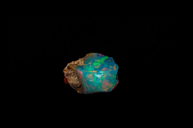 Opalas raras e bonitas da pedra mineral macro em um fundo preto