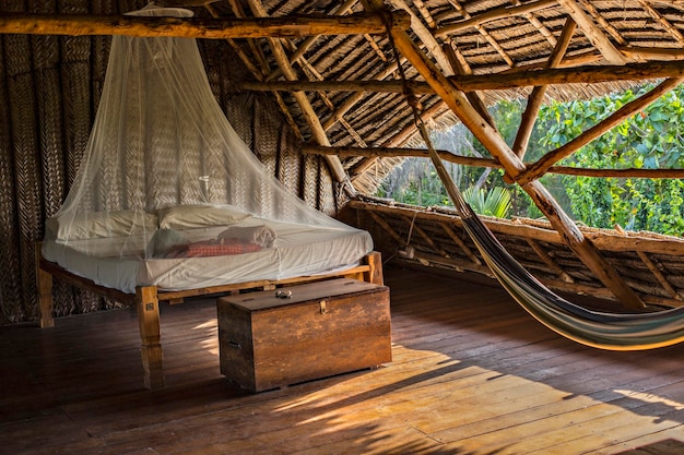 Open-Air-Herberge im traditionellen Sansibar-Stil mit Holzmöbeln, Hängematte und Moskitonetz