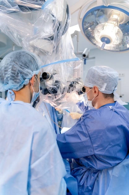 Operação em hospital. Conceito de cuidados de saúde. Equipe de cirurgiões trabalhando. Foco seletivo. Antecedentes da sala médica.