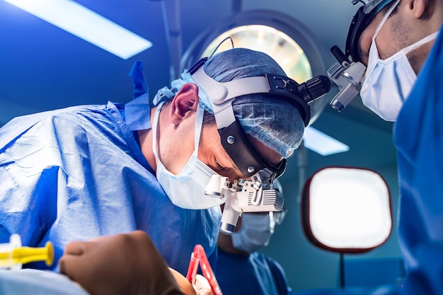 Operación quirúrgica dura realizada por un médico con máscara Equipo de cirugía profesional