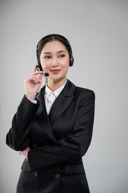 Operador asiático atractivo con traje formal y auriculares Entusiasta