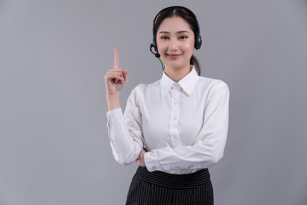 Operador asiático vestindo terno formal e fone de ouvido com o dedo apontando Entusiasmado