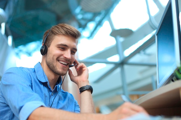 Operador de centro de llamadas masculino joven guapo sonriente amable