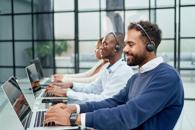 Operador de call center em fone de ouvido trabalhando no escritório