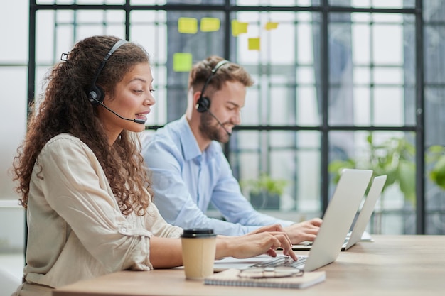operador de callcenter masculino com fones de ouvido sentado em um escritório moderno