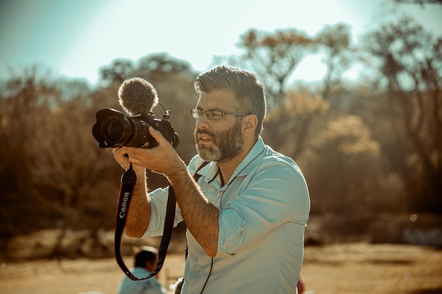 Operador de câmera de vídeo filmando ao ar livre