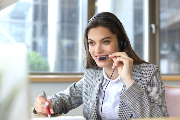 Operador de suporte ao cliente mulher com fone de ouvido e sorrindo.