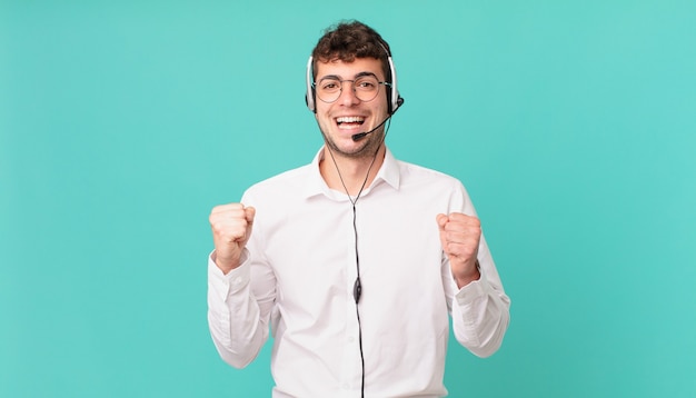 Operador de telemarketing se sentindo chocado, animado e feliz, rindo e comemorando o sucesso, dizendo uau!