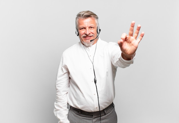 Operador de telemarketing sênior sentindo-se feliz, relaxado e satisfeito, mostrando aprovação com um gesto de ok, sorrindo