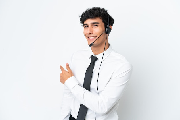 Operador de telemarketing trabalhando com um fone de ouvido isolado no fundo branco apontando para trás