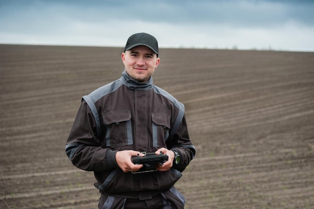 Operador de un dron agrícola con control remoto de dron para fumigación de campo