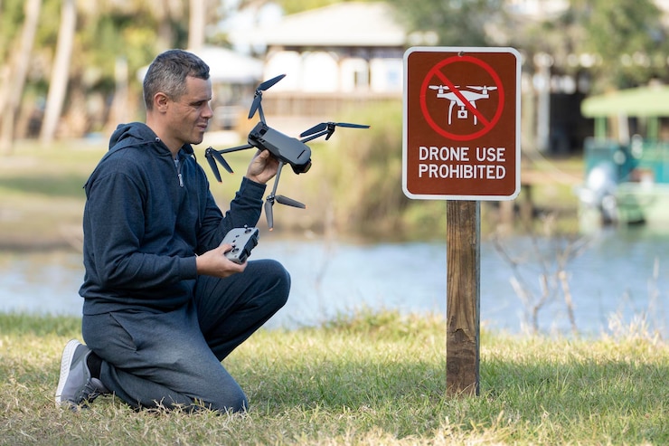 Foto el operador de drones está decepcionado porque no se le permite volar su cuadricóptero en un parque nacional sin área de drones el hombre no puede usar su uav cerca de la señal de aviso de restricción regulaciones de uso del espacio aéreo