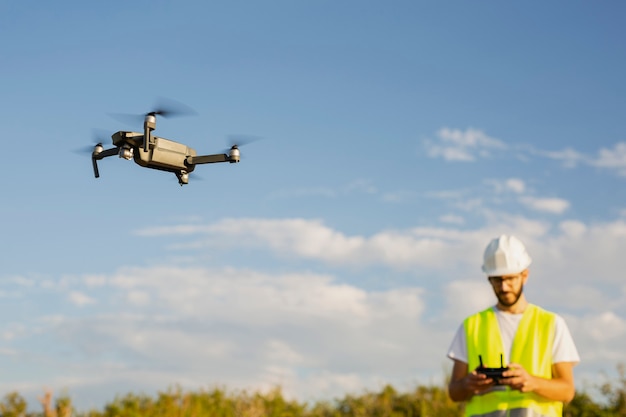 Operador de drones pilotando un dron en un entorno rural