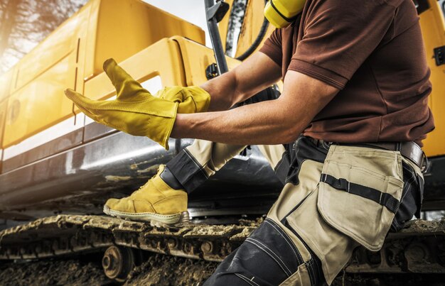 Foto operador de equipo de construcción pesada con guantes de seguridad