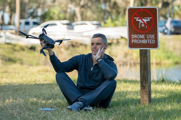 Foto el operador está decepcionado porque no puede volar su cuadricóptero en un parque nacional sin área de drones el hombre no puede usar su uav cerca de la señal de aviso de restricción