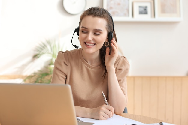 Operador freelance falando com fones de ouvido e clientes de consultoria em casa.