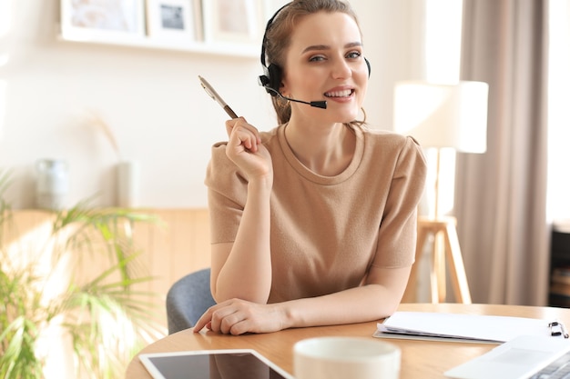Operador freelance falando com fones de ouvido e clientes de consultoria em casa.