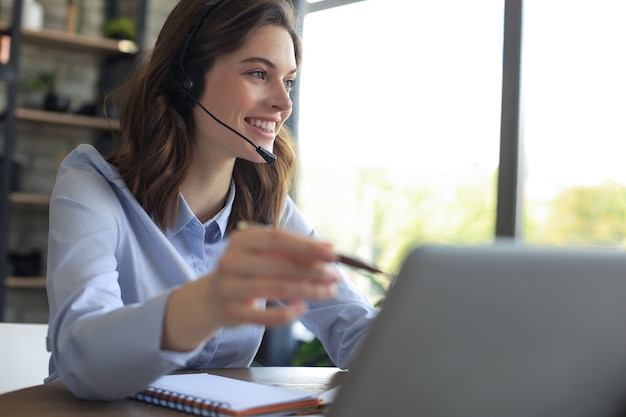 Operador freelance falando com fones de ouvido e clientes de consultoria em casa.