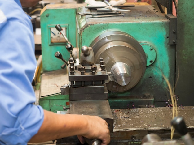 Operador girando piezas de moldes por torno manual