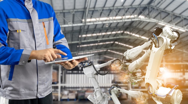 Operador de máquina industrial, brazo robótico en la fábrica.