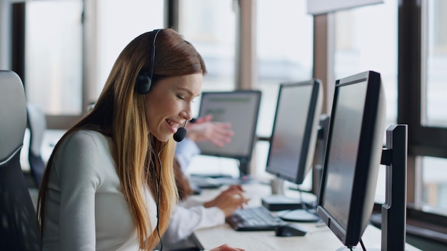 Operador sorridente digitando computador no centro de dados mulher alegre assistente no trabalho