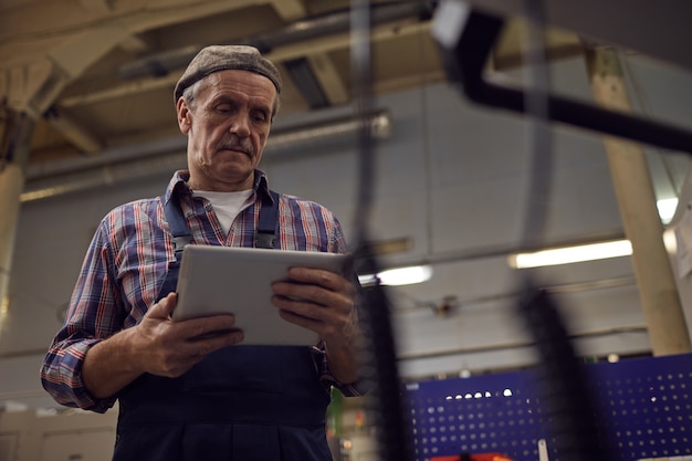 Operador con tablet pc en la fábrica