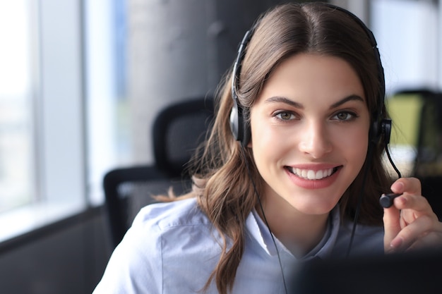 Operadora de suporte ao cliente feminino com fone de ouvido e sorrindo.