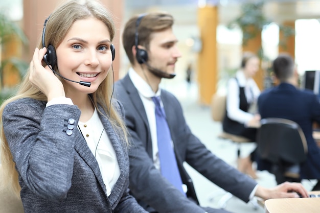 Operadora de suporte ao cliente feminino com fone de ouvido e sorrindo.