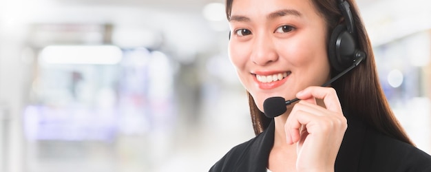 Operadora de telefone de suporte ao cliente de mulher bonita e sorridente asiática no fundo do espaço interior do escritório e espaço de cópiaconcept call center job center