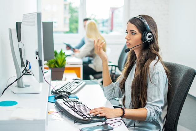 Operadora telefónica de servicio al cliente confundida mujer usando computadora en la oficina