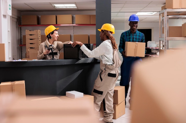 Operadores de almacén sonrientes charlando en la recepción haciendo inventario