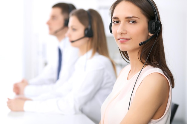Foto operadores de centros de llamadas. céntrese en la mujer de negocios hermosa joven en auriculares.